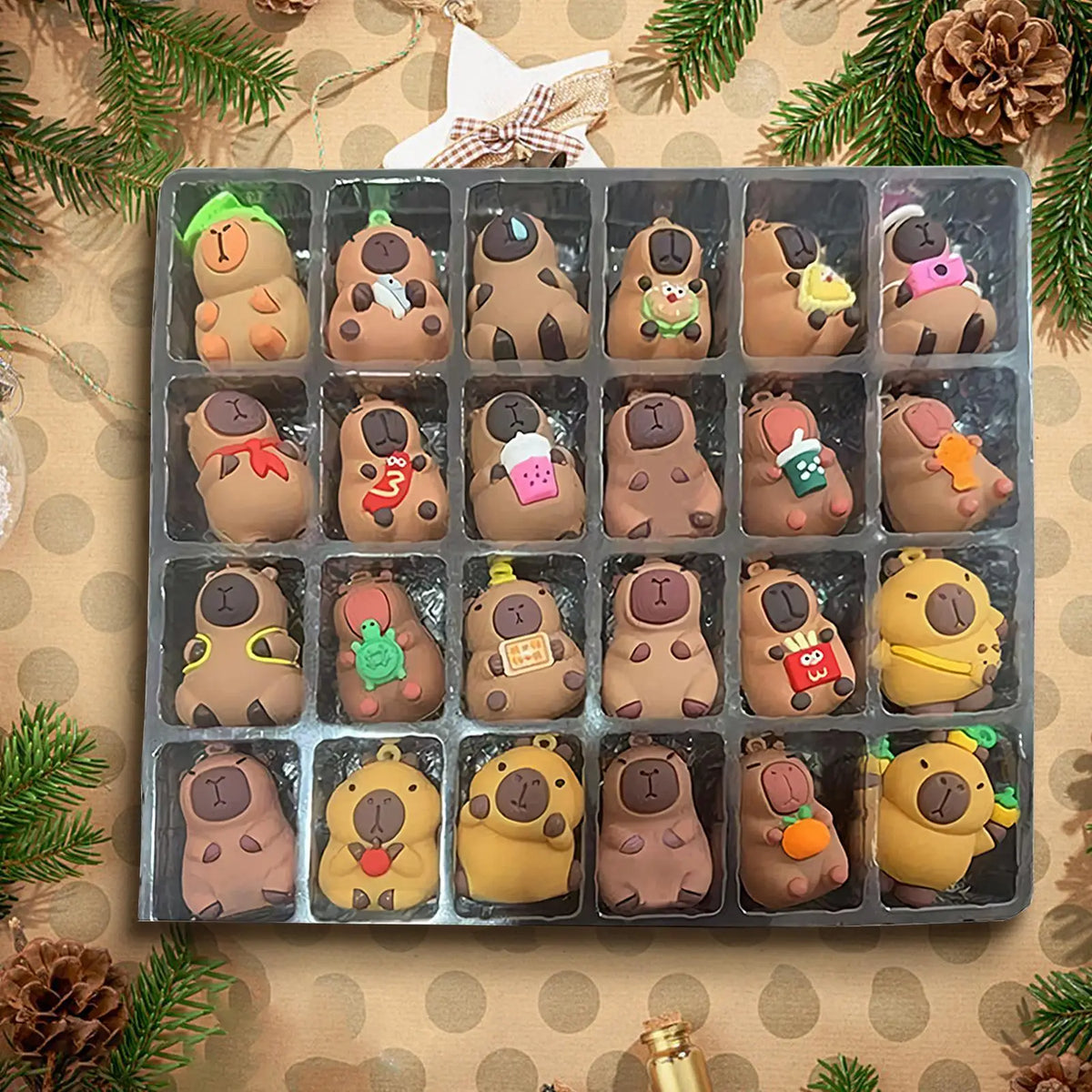 All 24 capybara mini figures in their clear tray, each in a different Christmas outfit